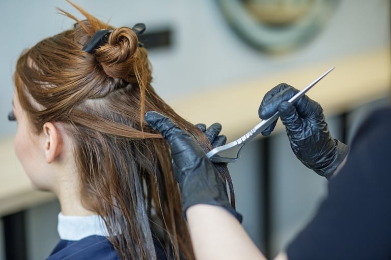 Professional hairdresser applying hair colour treatment in salon
