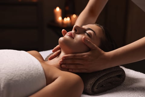 Woman enjoying relaxing face massage at spa