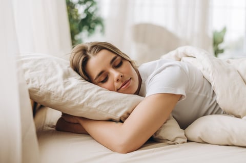Woman sleeping peacefully in cozy bed