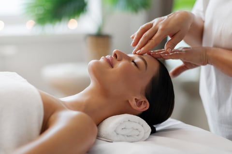 Woman receiving relaxing head massage at spa